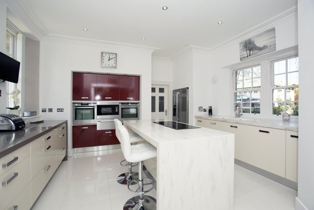 The modern, fitted kitchen has a central island with breakfast bar.