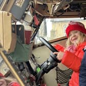 Some of the children explore the inside of the army vehicle.