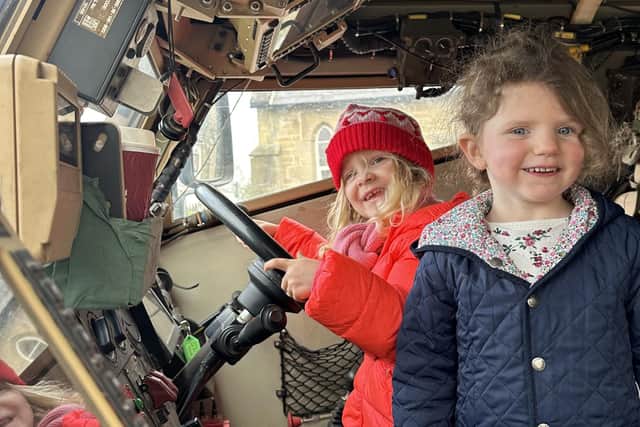 Some of the children explore the inside of the army vehicle.