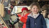 Some of the children explore the inside of the army vehicle.