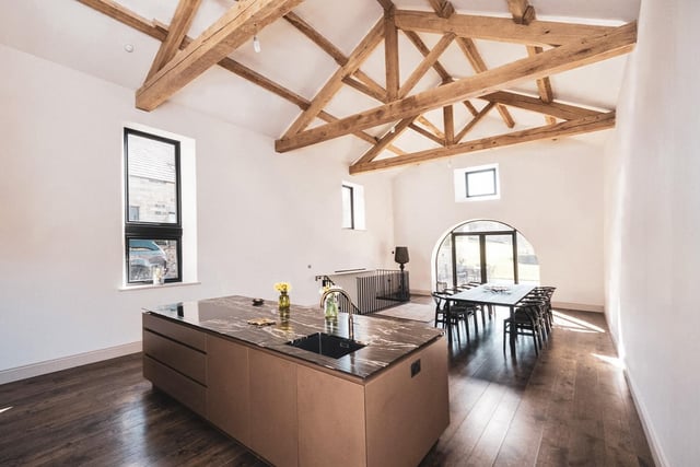 On one side and occupying an entire barn, is a fabulous contemporary Roundhouse Design kitchen with a large island and generous dining area.