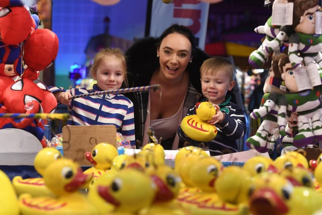 Pictured 4-year-old Georgiana White and her brother 3-year-old Ralph play hook a duck with their mum Lucy White.