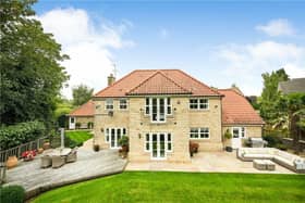 A rear view of the property and its gardens, with seating areas that have extensive views.