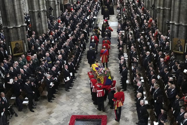 A Bearer Party of The Queen's Company, 1st Battalion Grenadier Guards carries the coffin of Queen Elizabeth II, draped in the Royal Standard, from the State Gun Carriage of the Royal Navy into Westminster Abbey. (Photo by Frank Augstein / POOL / AFP) (Photo by FRANK AUGSTEIN/POOL/AFP via Getty Images)