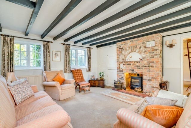A spacious yet cosy beamed lounge with feature fireplace and warming stove.
