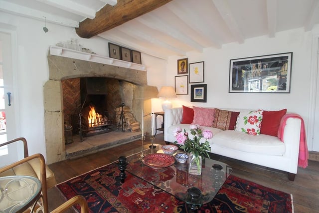 The living room has a warming open fire and reclaimed timber floor.