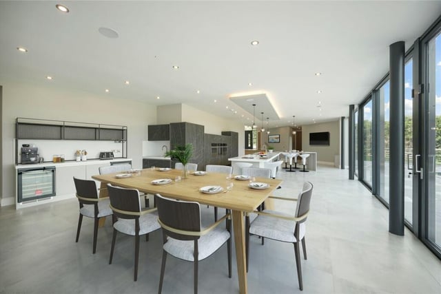 The 53ft open plan dining kitchen is sleek and bright, with bespoke units and a central island.