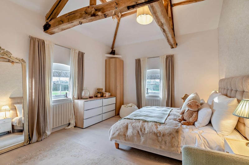 A bright and comfortable double bedroom with exposed beams.