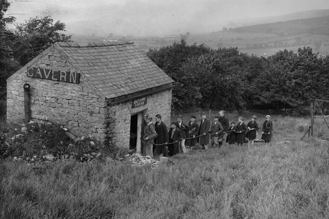 A party of schoolboys queue up to explore the newly-discovered passage at Bagshwe Cavern, Bradwell in 1936