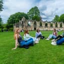 Visitors to York enjoying the warm weather while relaxing in York Museum Gardens.