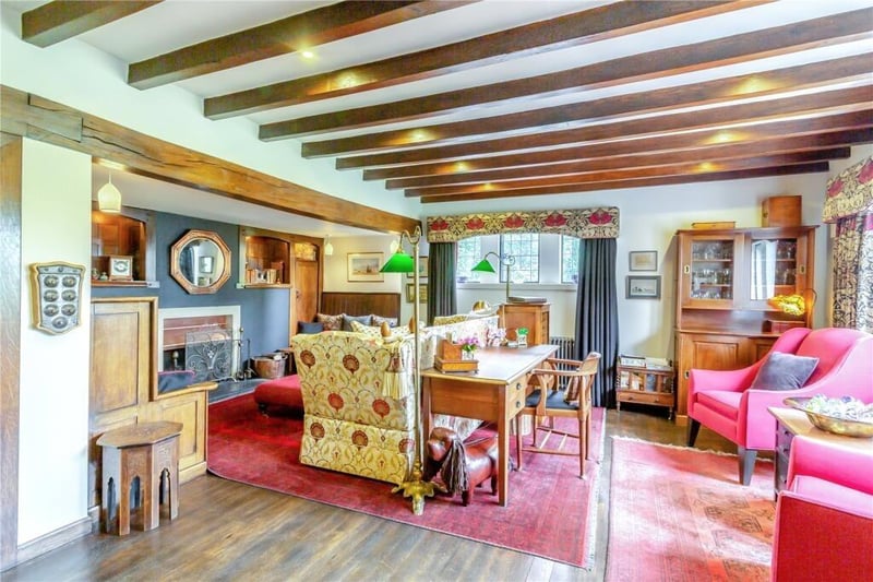 A view of the sitting room, showing the fireplace in the beamed sitting room.