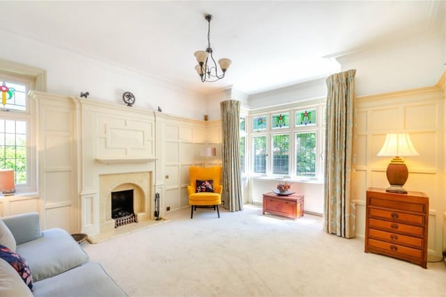 A bright family room, with panelled wall and feature fireplace.