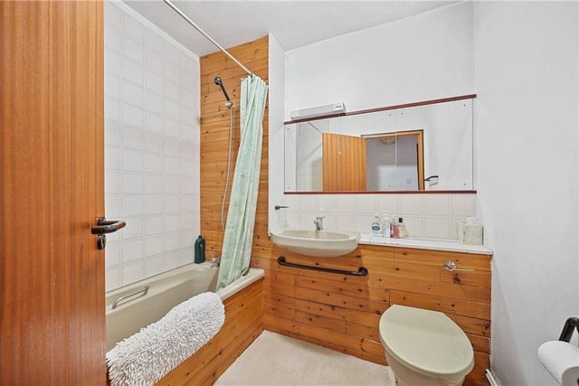 A bathroom with wash basin vanity unit, bath and shower.