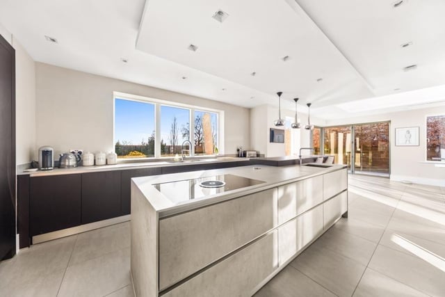 The sleek, open plan living and dining kitchen has Miele appliances and bespoke cabinetry.