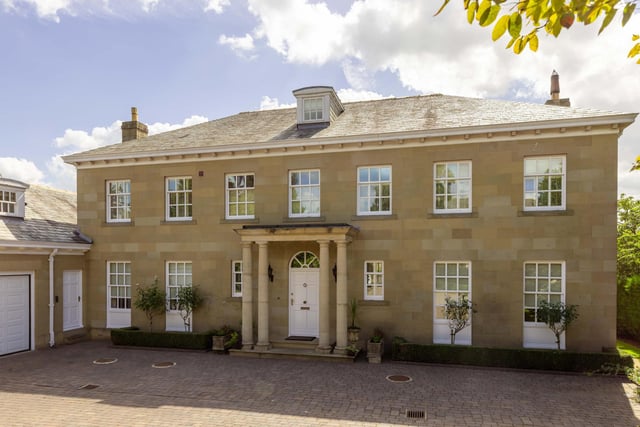 The front facade of the property with sandstone exterior and sash windows.