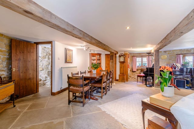 A sitting and dining area with flagstone flooring fill the main floor space at ground floor level.