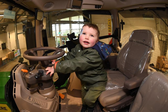 Austyn Manderson, aged three, gets to grips with the John Deere tractor