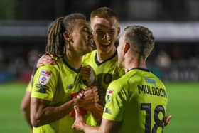 Miles Welch-Hayes, left, celebrates with Kyle Ferguson, centre, and Jack Muldoon after heading home Harrogate Town's last-gasp winner against Morecambe. Pictures: Matt Kirkham