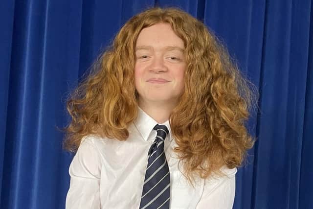 Teenager shows off his long red curly hair before the charity chop takes place.