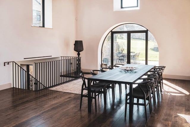 The dining area has a vaulted ceiling showcasing the striking oak 'A frame' trusses and a large picture window/doors framing the propertie's uninterrupted views.