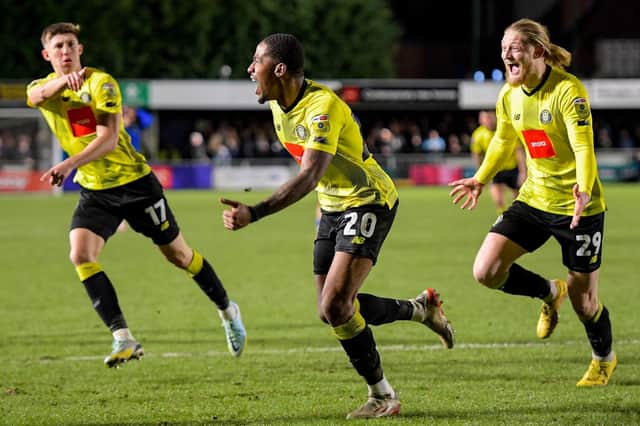 Harrogate Town defender Kayne Ramsay, centre, celebrates after his stoppage-time strike is deflected over the goal-line by Grimsby Town stopper Max Crocombe. Pictures: Ben Roberts/ProSportsImages