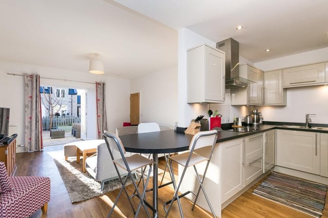 Semi-open to the lounge, the kitchen is set to the rear with stone-effect worktops and a breakfast bar.