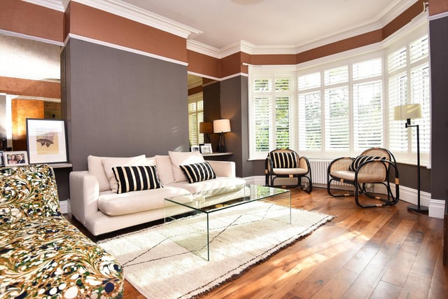 A large bay window allows natural light to pour in to this open plan living space.