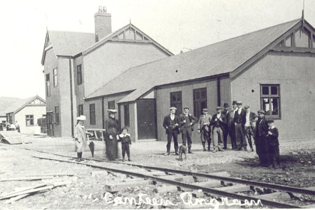 The large two storey building and long single storey section is a shop and a canteen, whilst the building behind is believed to be the Mission church.