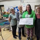 Harrogate food poverty group Resurrected Bites receives a cheque from Laura Dudley of Painting Pots Knaresborough. Also pictured is Café volunteer Val Hills, fomer president of Harrogate and District Soroptimists. (Picture contributed)