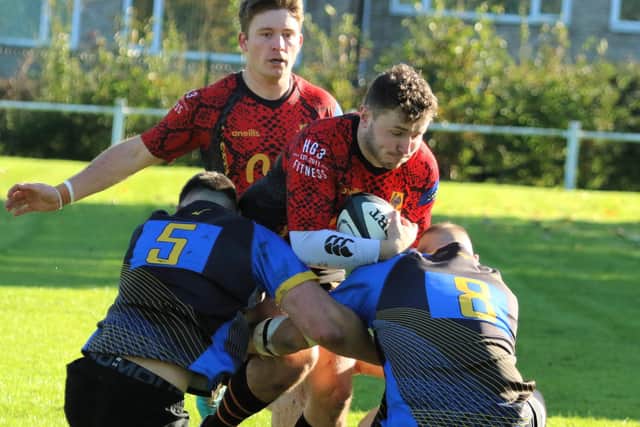 Sam Rowntree is tackled by a pair of Bradford Salem defenders.