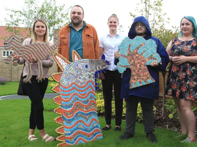 Creators from Henshaws photographed with their mosaics at Bovis Homes’ Spring Vale development