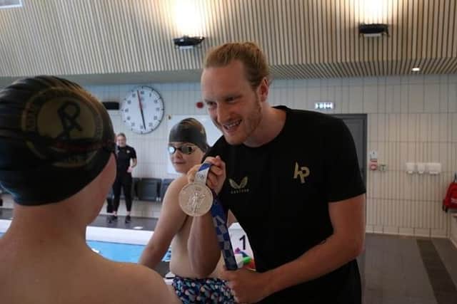 British Olympic swimming hero Luke Greenbank shows off a medal at a previous swimming clinic at Harrogate’s Ashville College.