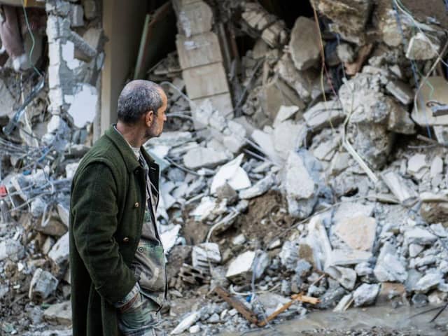A man walks past a collapsed building in the town of Jbaleh in Syria's northwestern province of Latakia following the earthquake.
