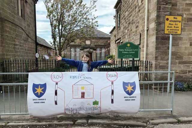 Road safety banner - Y4 pupil Ava Baron outside Ripley School.