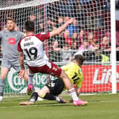 Kieron Bowie volleys Northampton Town's third goal past Harrogate Town stopper Mark Oxley during Saturday's League Two clash at Sixfields. Pictures: Pete Norton/Getty Images