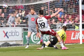 Kieron Bowie volleys Northampton Town's third goal past Harrogate Town stopper Mark Oxley during Saturday's League Two clash at Sixfields. Pictures: Pete Norton/Getty Images