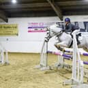 Cassie Holliday mid-jump riding her pony 'Shanbo Dun'