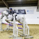 Cassie Holliday mid-jump riding her pony 'Shanbo Dun'