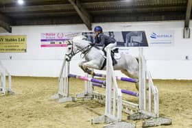 Cassie Holliday mid-jump riding her pony 'Shanbo Dun'