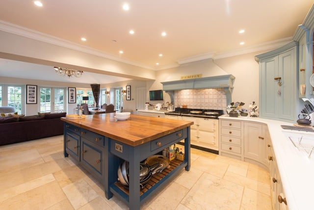 The open plan dining kitchen has bespoke cabinetry, a central island with a walnut worktop, and a gas fired aga.