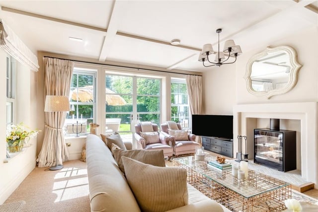 A light and spcious dual aspect living room has a wood burner, and French doors out to the terrace.