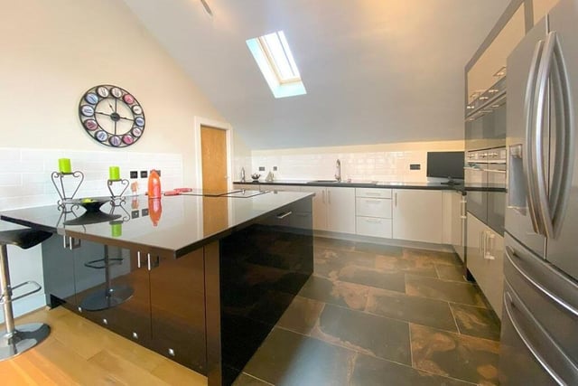 The stylish kitchen has a large island unit with breakfast bar.