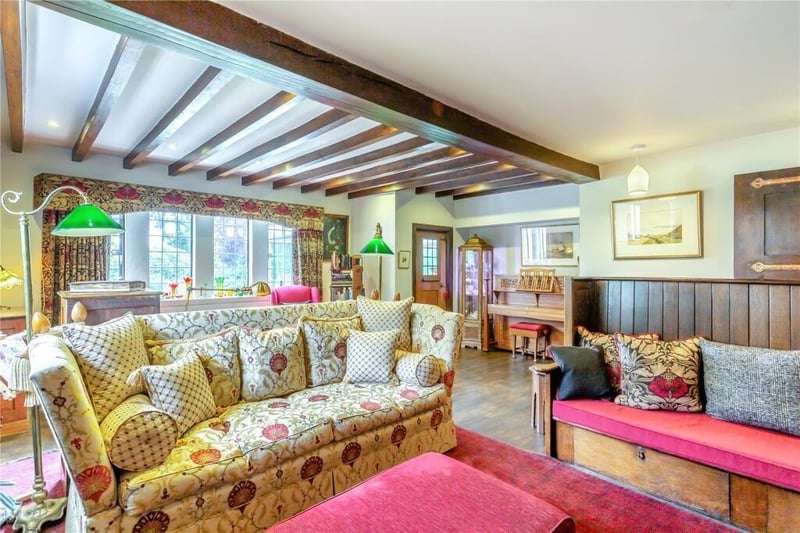 A stunning part-beamed living room has an inglenook open fireplace, with built-in seating.