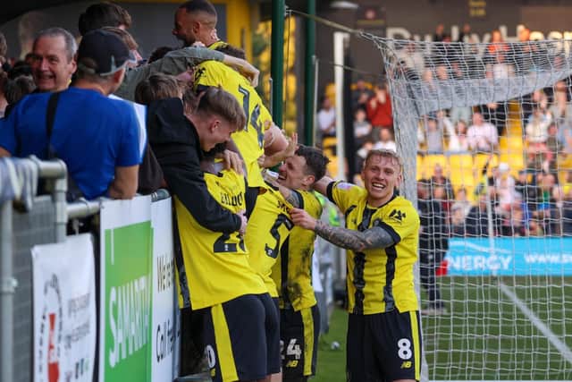 The Sulphurites celebrate their 95th-minute winner with the home fans.