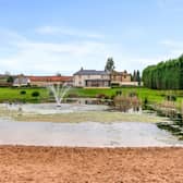 The property's five acres includes a beach and lake, that is suitable for swimming.