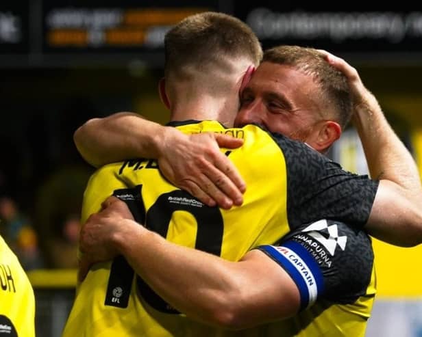 Harrogate Town captain George Thomson is congratulated by team-mate Matty Daly after netting what proved to be the winning goal during Tuesday night's League Two clash with Grimsby. Picture: Harrogate Town AFC