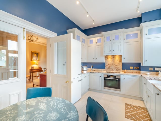 The kitchen, with bespoke units, has space for a small dining suite.