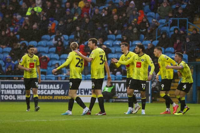 Harrogate Town's players celebrate after Paul Huntington's 82nd-minute own goal handed them the lead at Brunton Park.