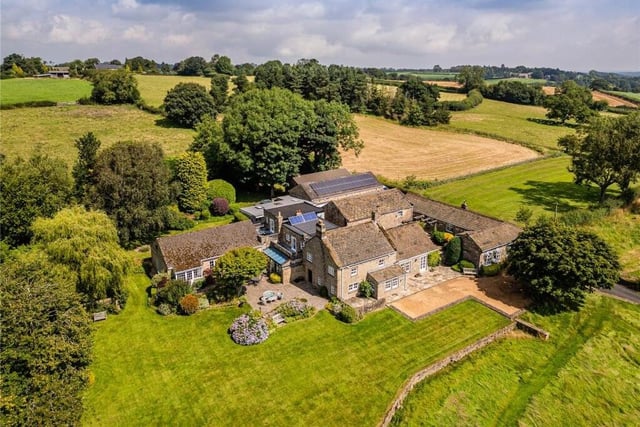 An aerial view of the farmhouse property within its picturesque surroundings.