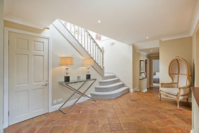 A bright and spacious hallway has stairs leading to the first floor.